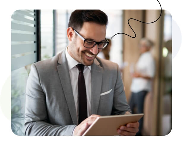 A man looking at a tablet while smiling