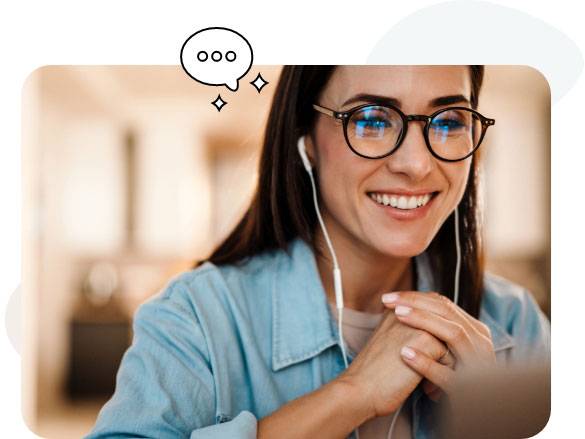 Una mujer lleva gafas y auriculares mientras utiliza su ordenador portátil.