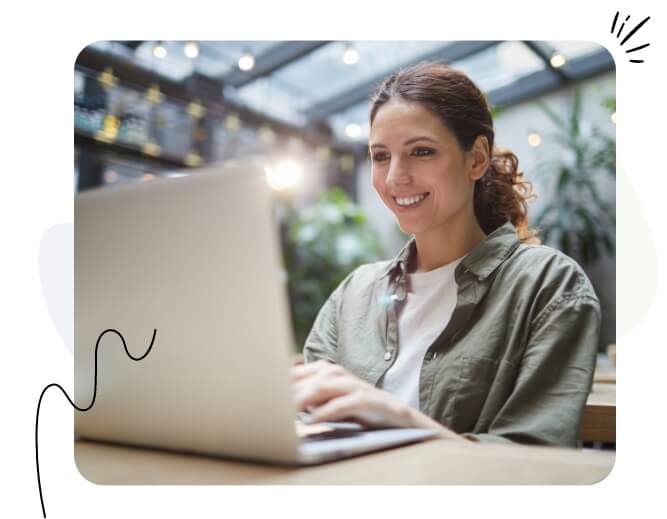 Una mujer feliz mirando su computadora portátil.