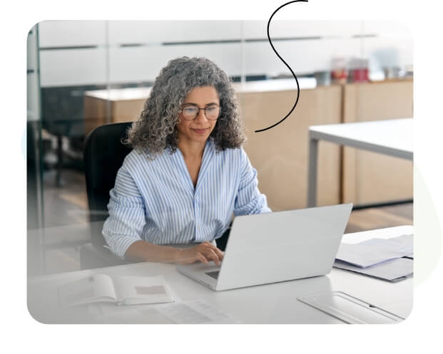 Una mujer feliz mirando su computadora portátil.