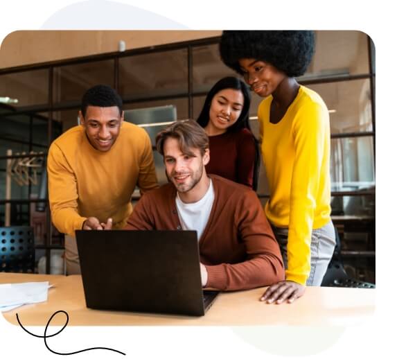 Un grupo diverso de profesionales colaborando en una computadora portátil en un entorno de oficina moderno.